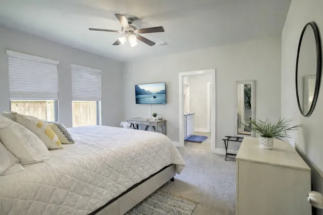 a bedroom with a large bed and a chandelier