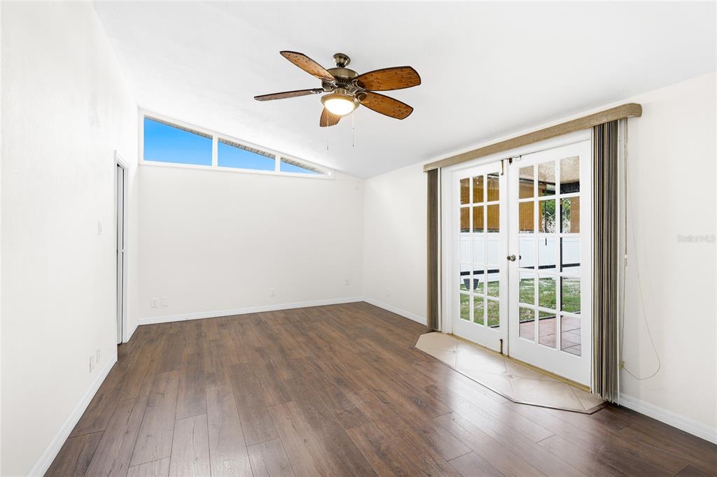 3452 Desoto Road Sarasota, FL 34235 - Photo 19 of 42 a view of an empty room with wooden floor and a ceiling fan