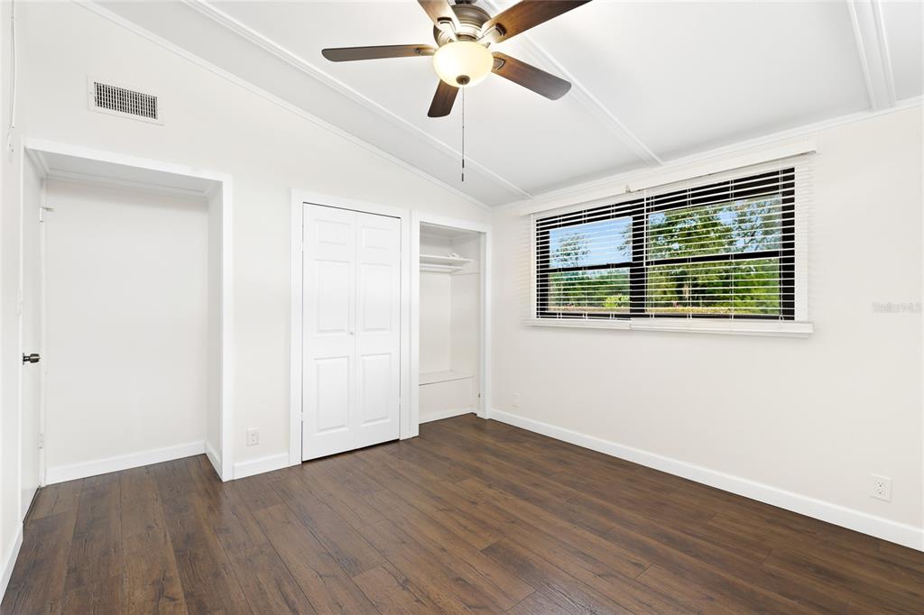3452 Desoto Road Sarasota, FL 34235 - Photo 24 of 42 a view of an empty room with wooden floor and a ceiling fan