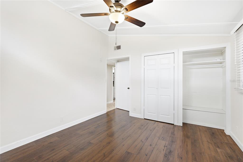 3452 Desoto Road Sarasota, FL 34235 - Photo 25 of 42 an empty room with wooden floor ceiling fan and windows