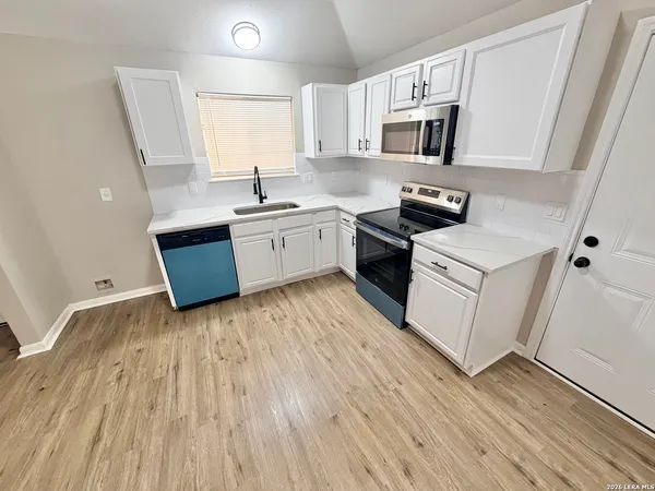 a kitchen with wooden floors and white appliances