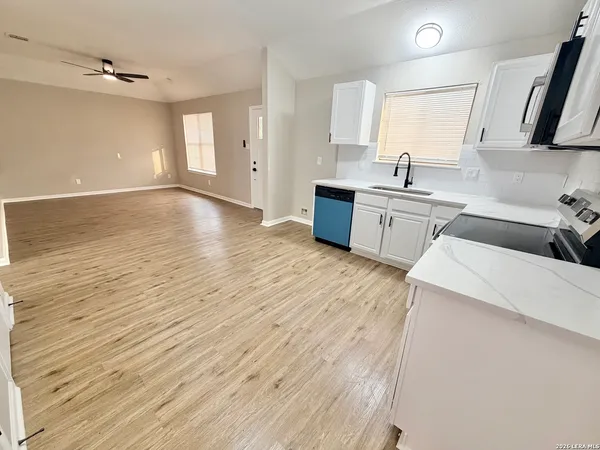 a kitchen with stainless steel appliances granite countertop a sink a stove top oven a counter space and cabinets