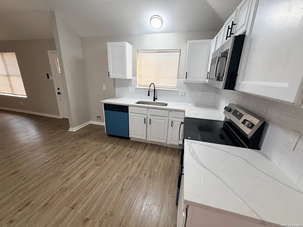 a kitchen with a sink a stove and cabinets