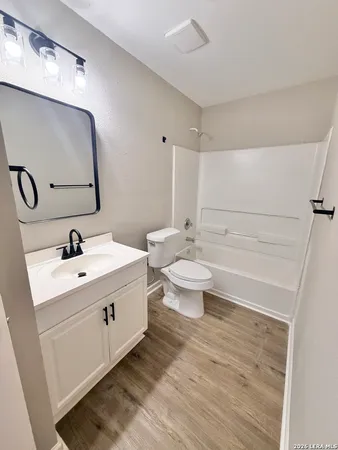 a bathroom with a double vanity sink mirror and toilet