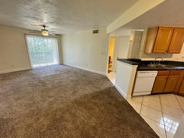 a view of a kitchen with wooden floor and a window
