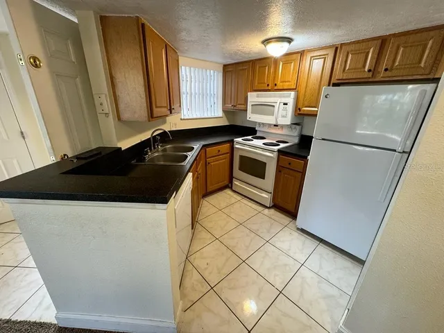 a kitchen with a refrigerator sink and cabinets