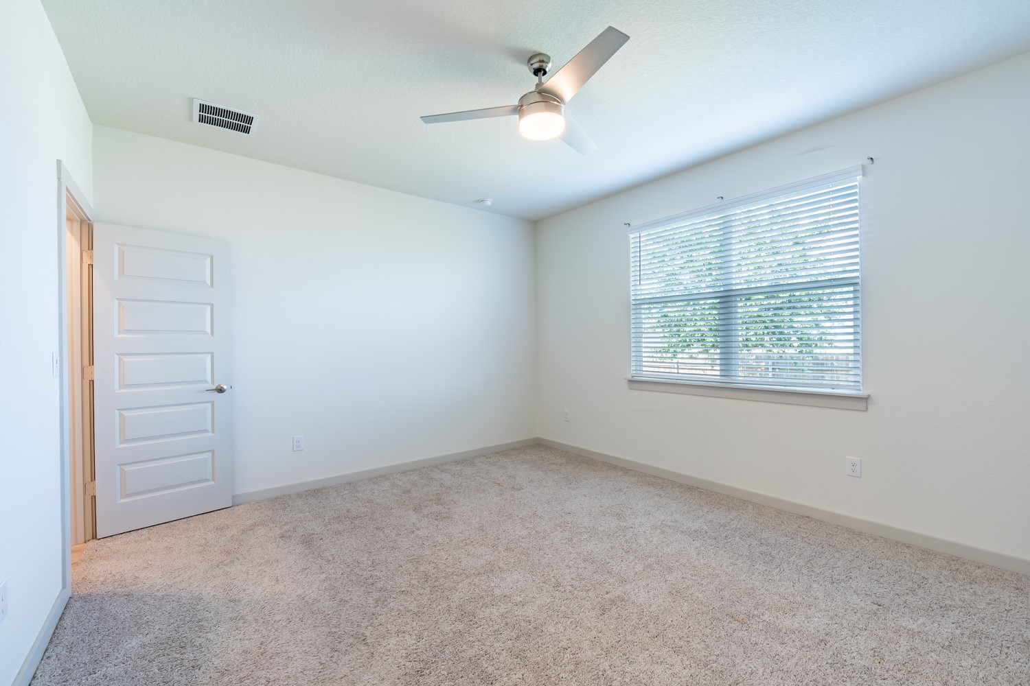 10801 Meris Lane Austin, TX 78754 - Photo 11 of 18 A well-lit bedroom features plush carpet and a modern ceiling fan for ultimate comfort.