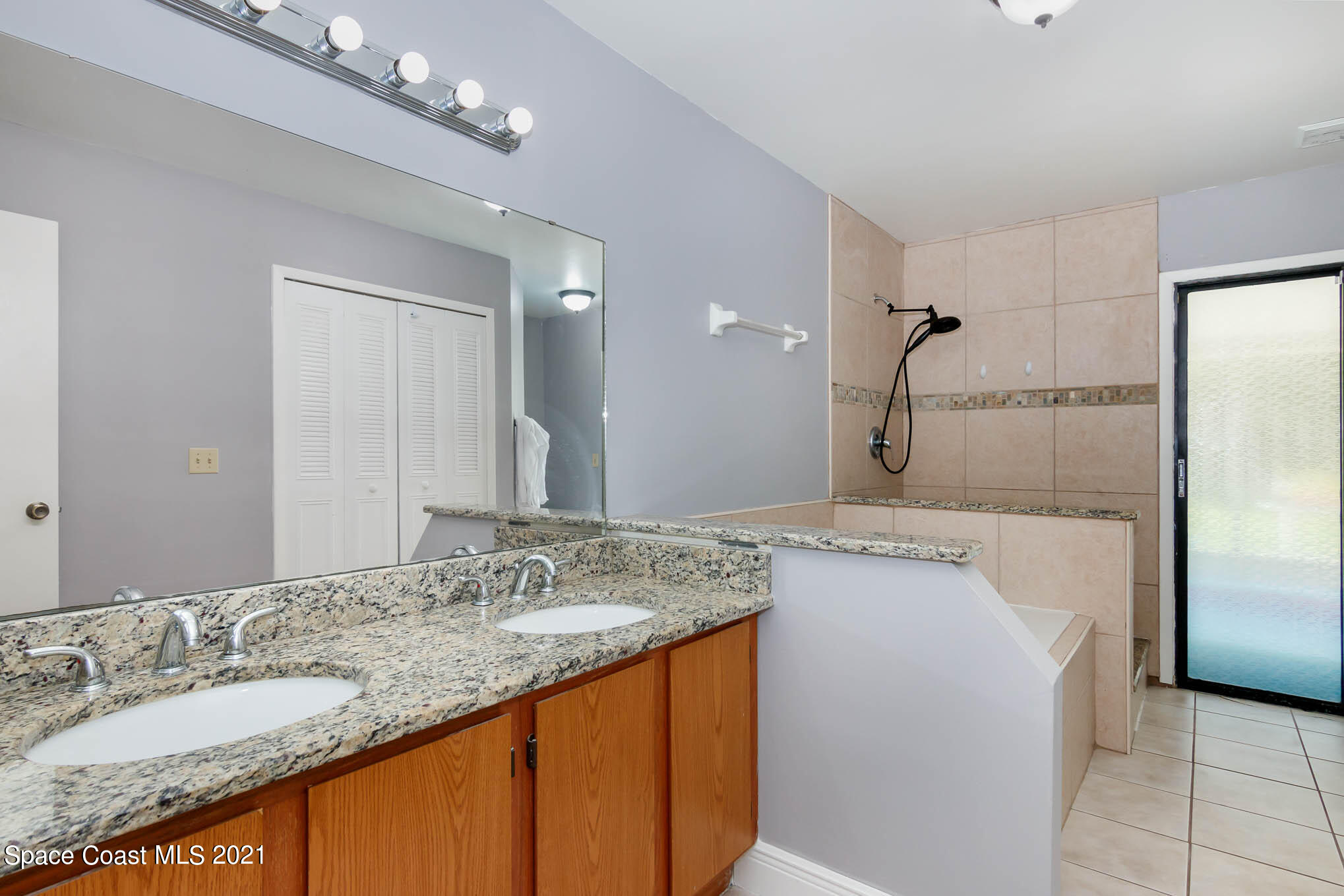 5617 Flint Road Cocoa, FL 32927 - Photo 15 of 25 a bathroom with a granite countertop sink a shower and a mirror