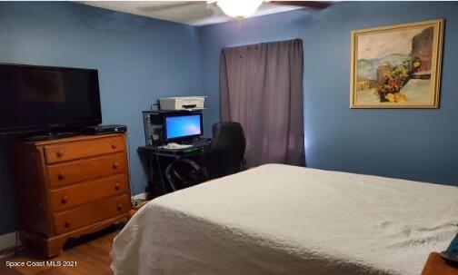 5617 Flint Road Cocoa, FL 32927 - Photo 22 of 25 a bedroom with a bed and a flat screen tv