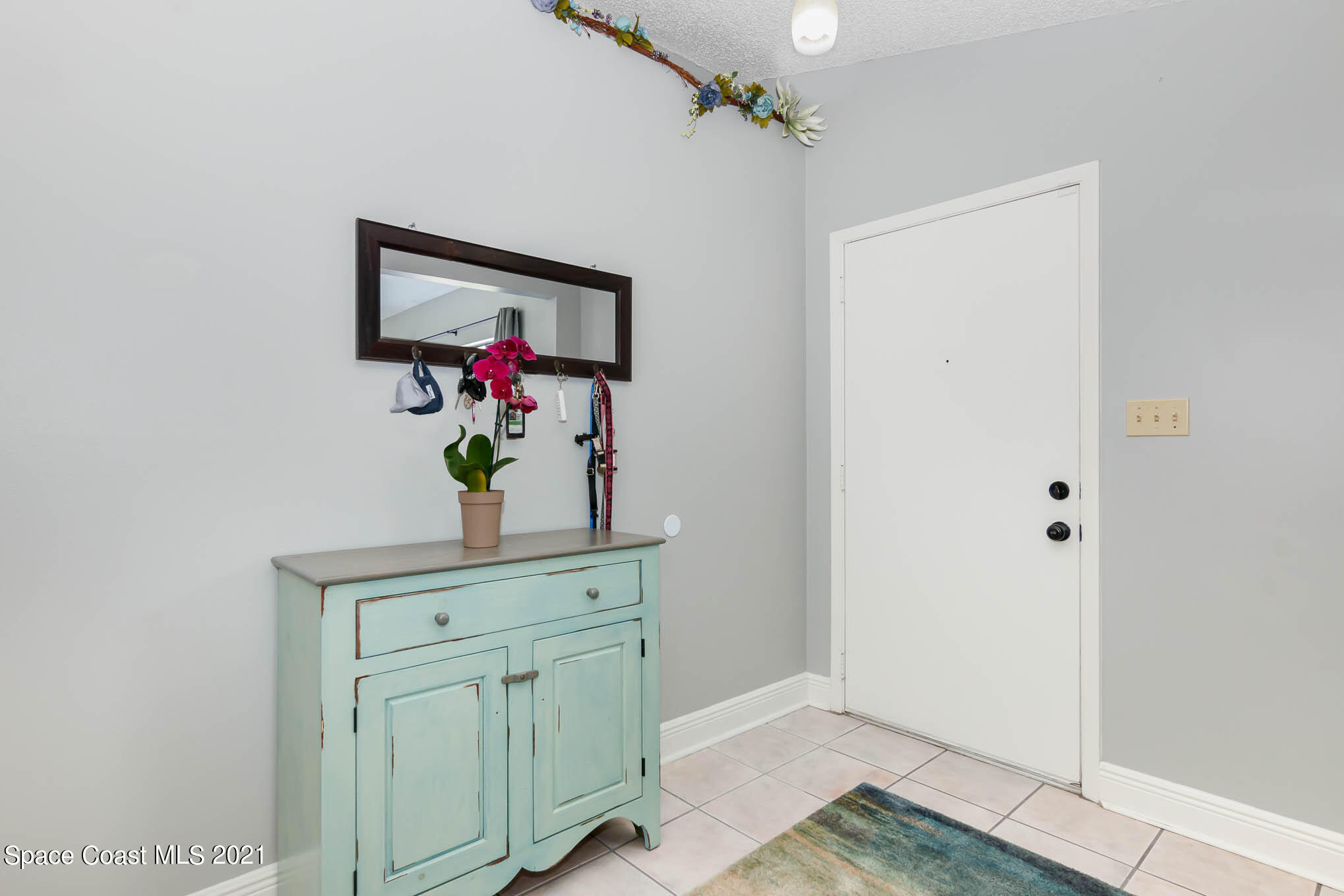 5617 Flint Road Cocoa, FL 32927 - Photo 4 of 25 a view of hallway with mirror and wooden floor