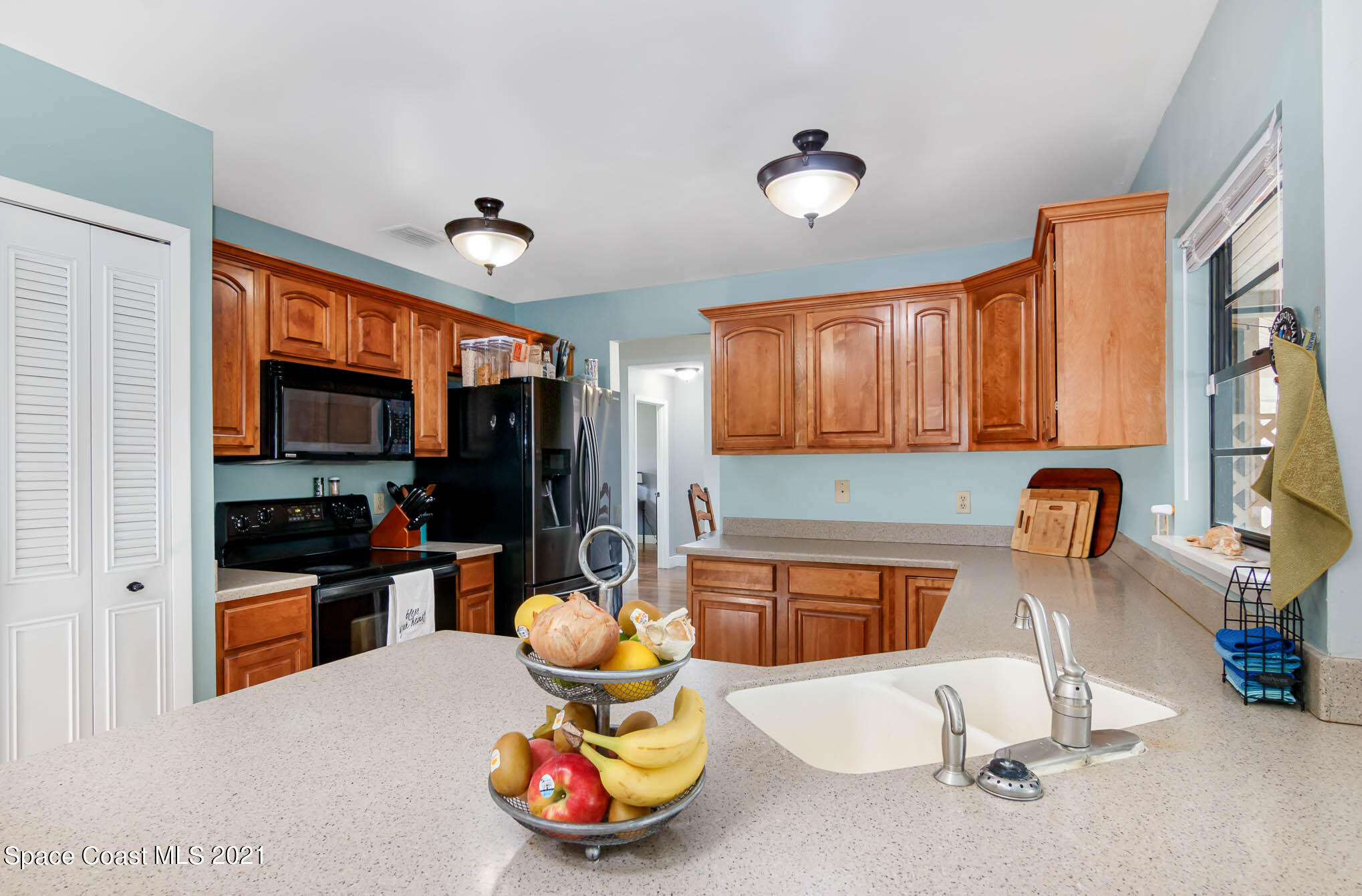 5617 Flint Road Cocoa, FL 32927 - Photo 5 of 25 a kitchen with dining area and wooden cabinets