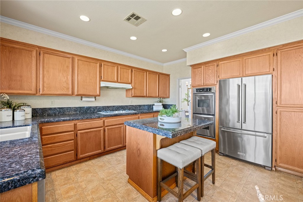 5118 Avenida De La Plata Oceanside, CA 92057 - Photo 11 of 42 a kitchen with stainless steel appliances granite countertop a refrigerator a sink dishwasher a stove with wooden cabinets and floor