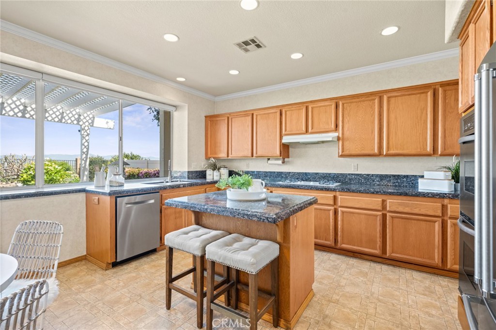 5118 Avenida De La Plata Oceanside, CA 92057 - Photo 10 of 42 a kitchen with stainless steel appliances granite countertop wooden cabinets a sink and a stove