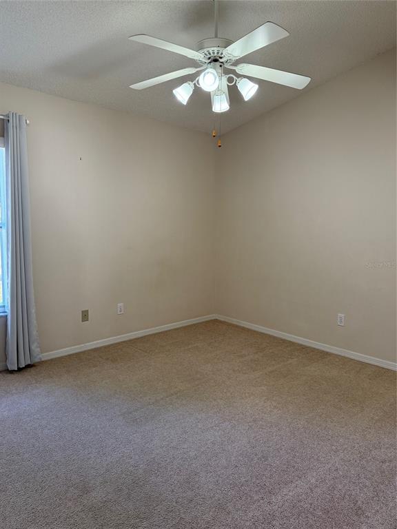 4501 River Ridge Drive Leesburg, FL 34748 - Photo 12 of 16 an empty room with a window and a fan