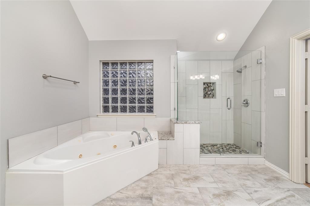 5801 Yeary Road Plano, TX 75093 - Photo 26 of 33 Corner jetted tub with a glass block window and a tiled surround