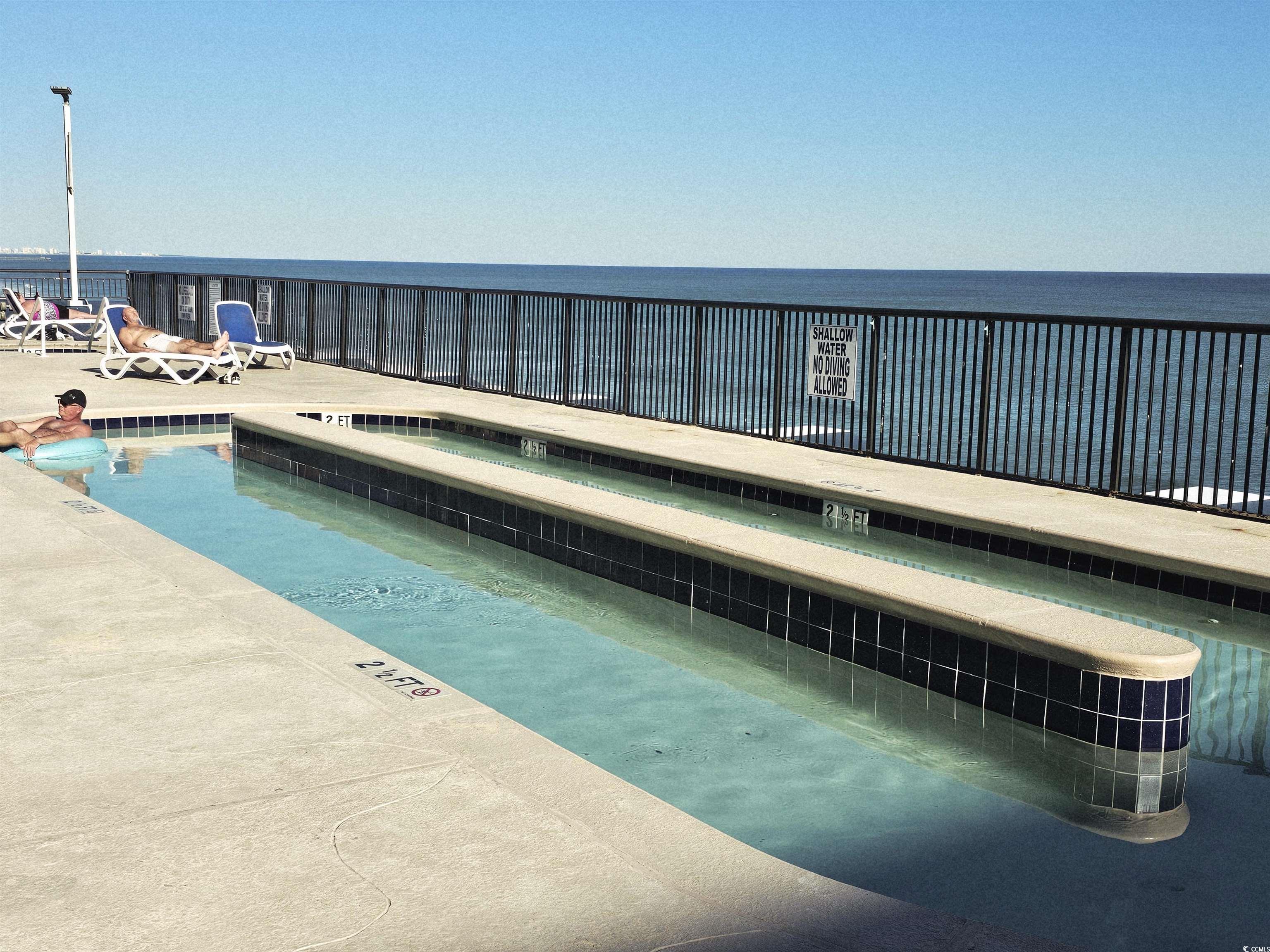 201 77th Avenue North, Unit 1025 Myrtle Beach, SC 29572 - Photo 17 of 36 Community pool featuring a water view and a hot tub