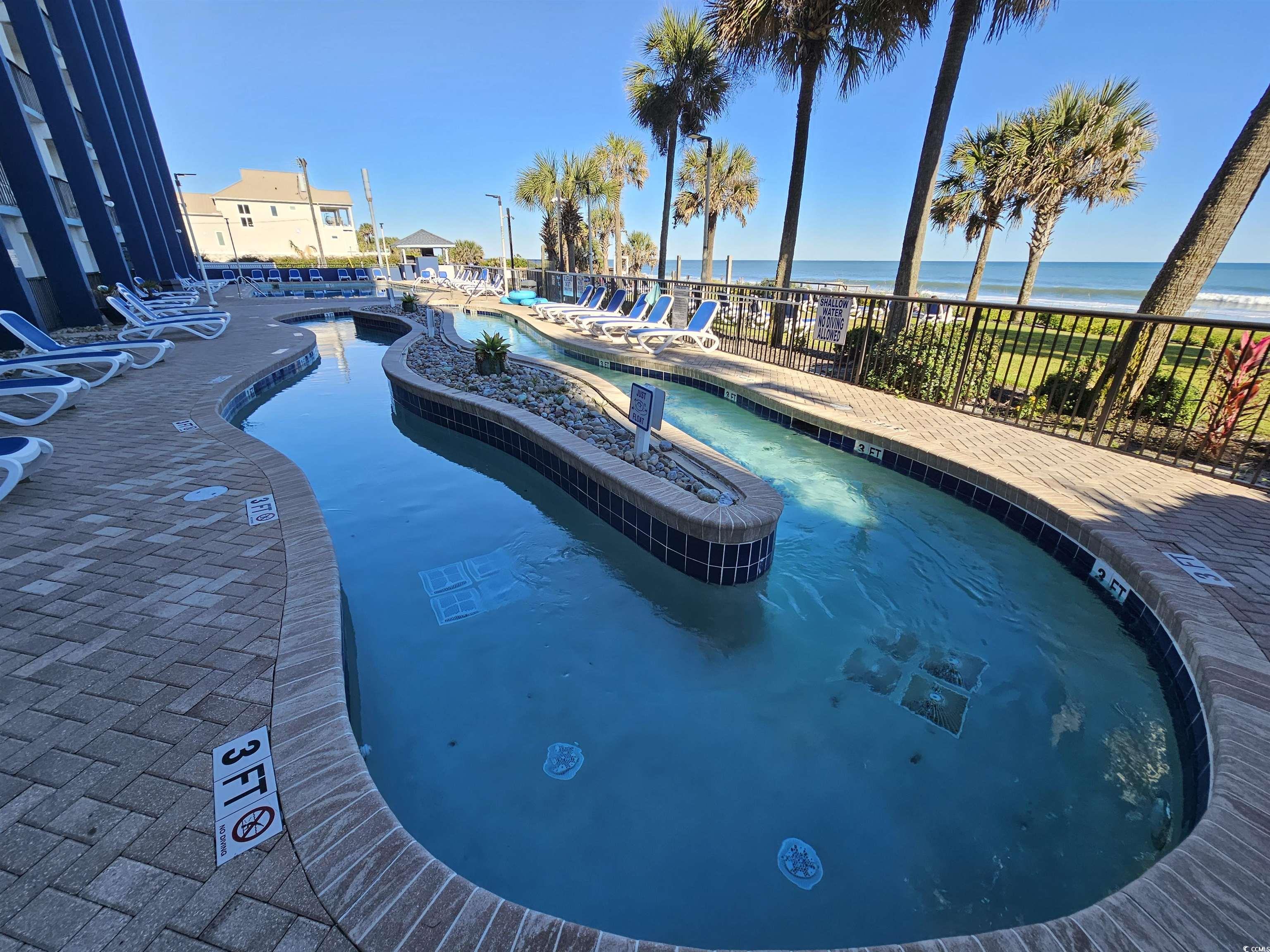 201 77th Avenue North, Unit 1025 Myrtle Beach, SC 29572 - Photo 25 of 36 Community pool featuring a patio area and a water view