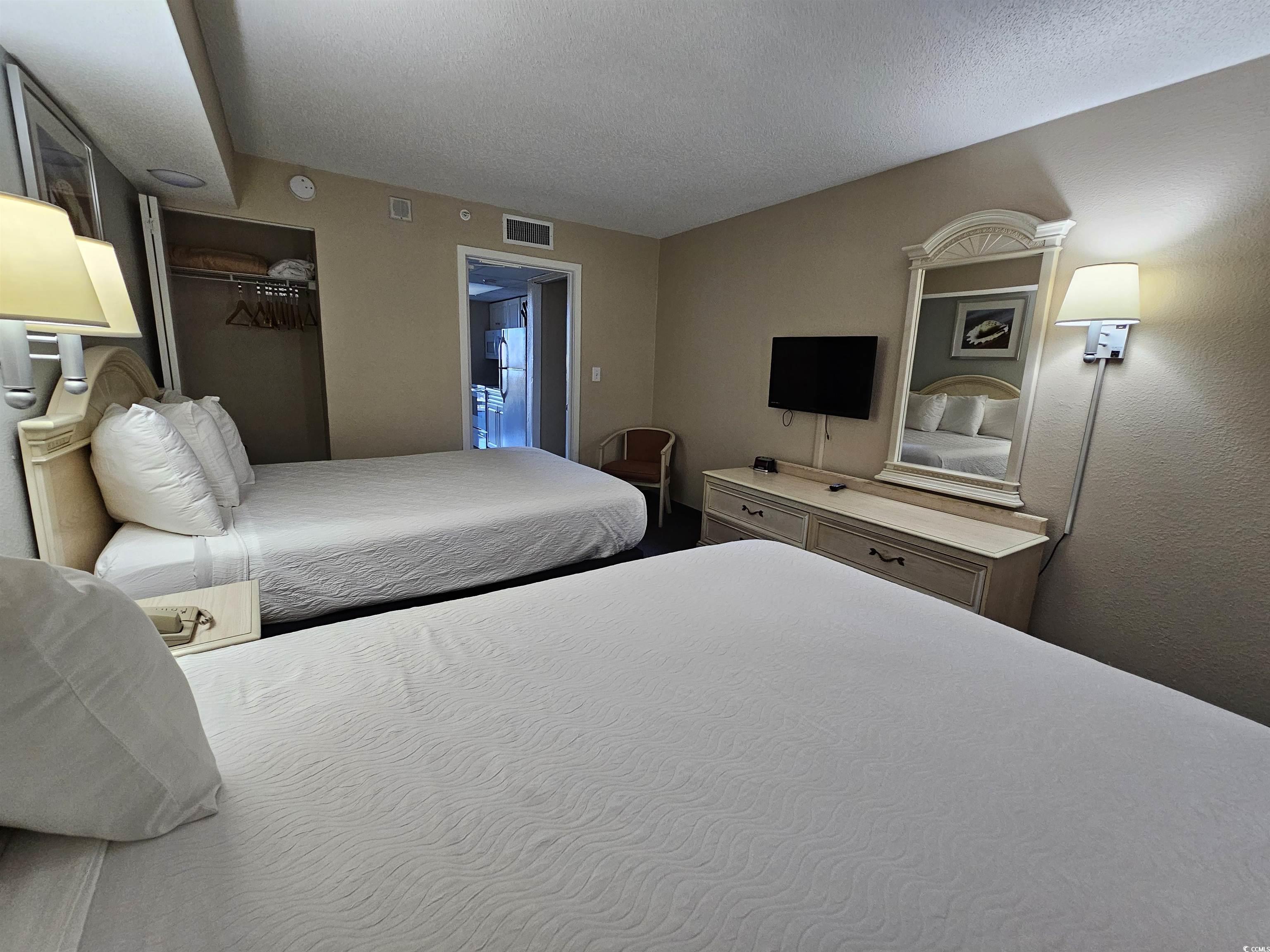 201 77th Avenue North, Unit 1025 Myrtle Beach, SC 29572 - Photo 5 of 36 Bedroom with a closet, a textured ceiling, and freestanding refrigerator