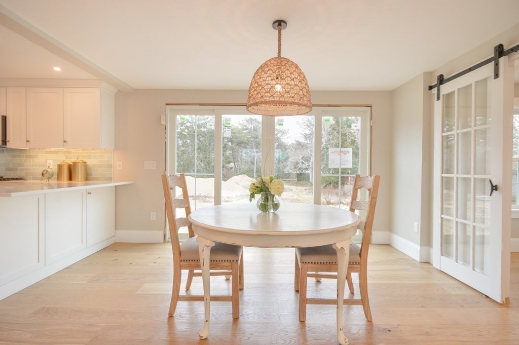 52 Uncle Barneys Road Dennis, MA 02670 - Photo 11 of 42 a view of a dining room with furniture wooden floor and a chandelier