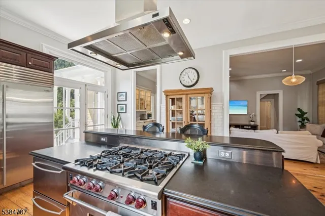 a large kitchen with stainless steel appliances granite countertop a stove and a table
