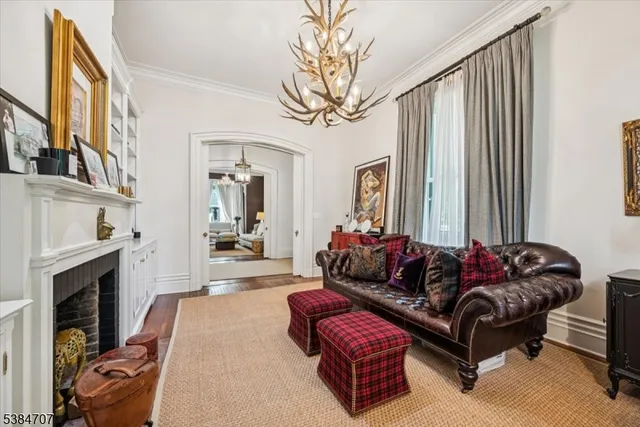a living room with furniture a fireplace and a large mirror next to a window
