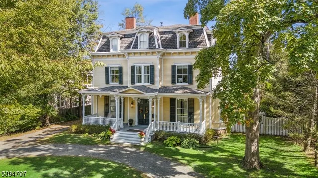 an aerial view of a house with a yard and mountains