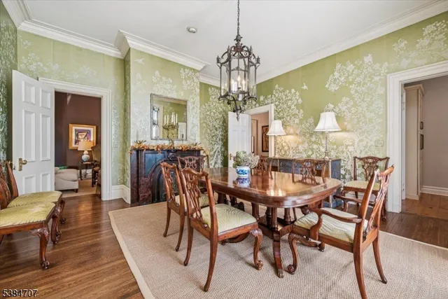 a dining room with furniture a chandelier and wooden floor