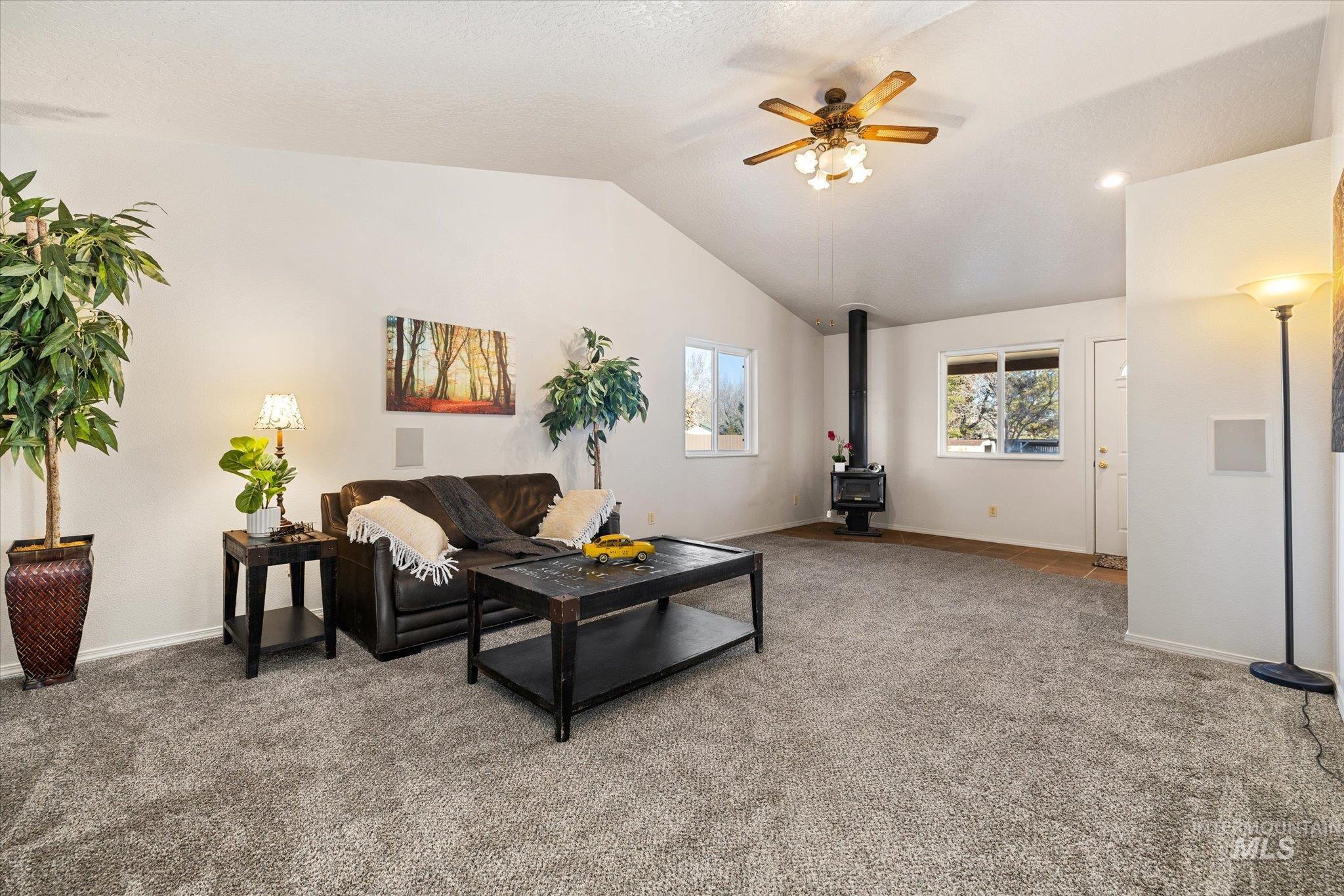 9820 Highway 44 Middleton, ID 83644 - Photo 16 of 50 Living room featuring a ceiling fan, a wood stove, carpet, and lofted ceiling