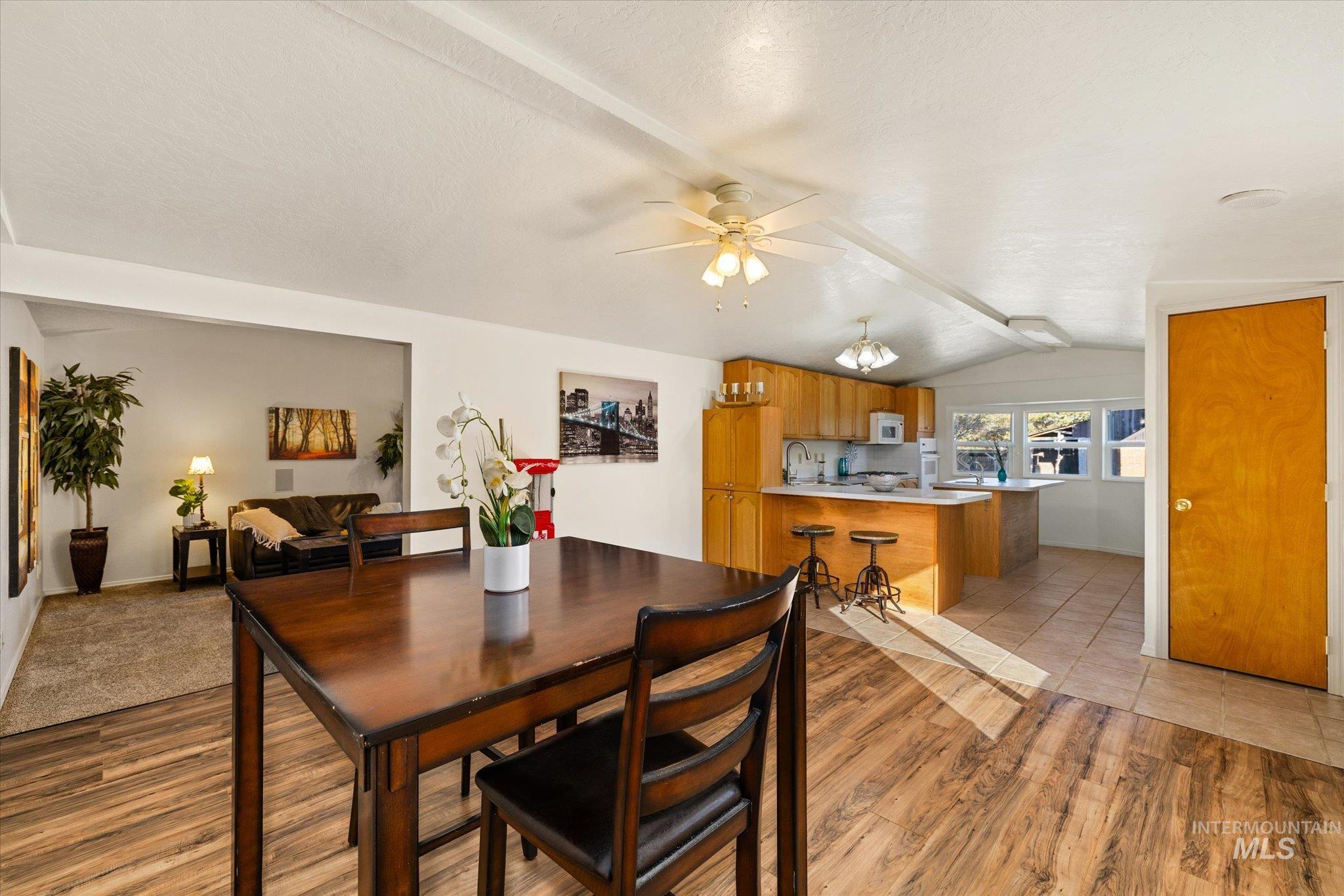 9820 Highway 44 Middleton, ID 83644 - Photo 18 of 50 Dining area featuring light wood-style flooring, a ceiling fan, beam ceiling, and a textured ceiling