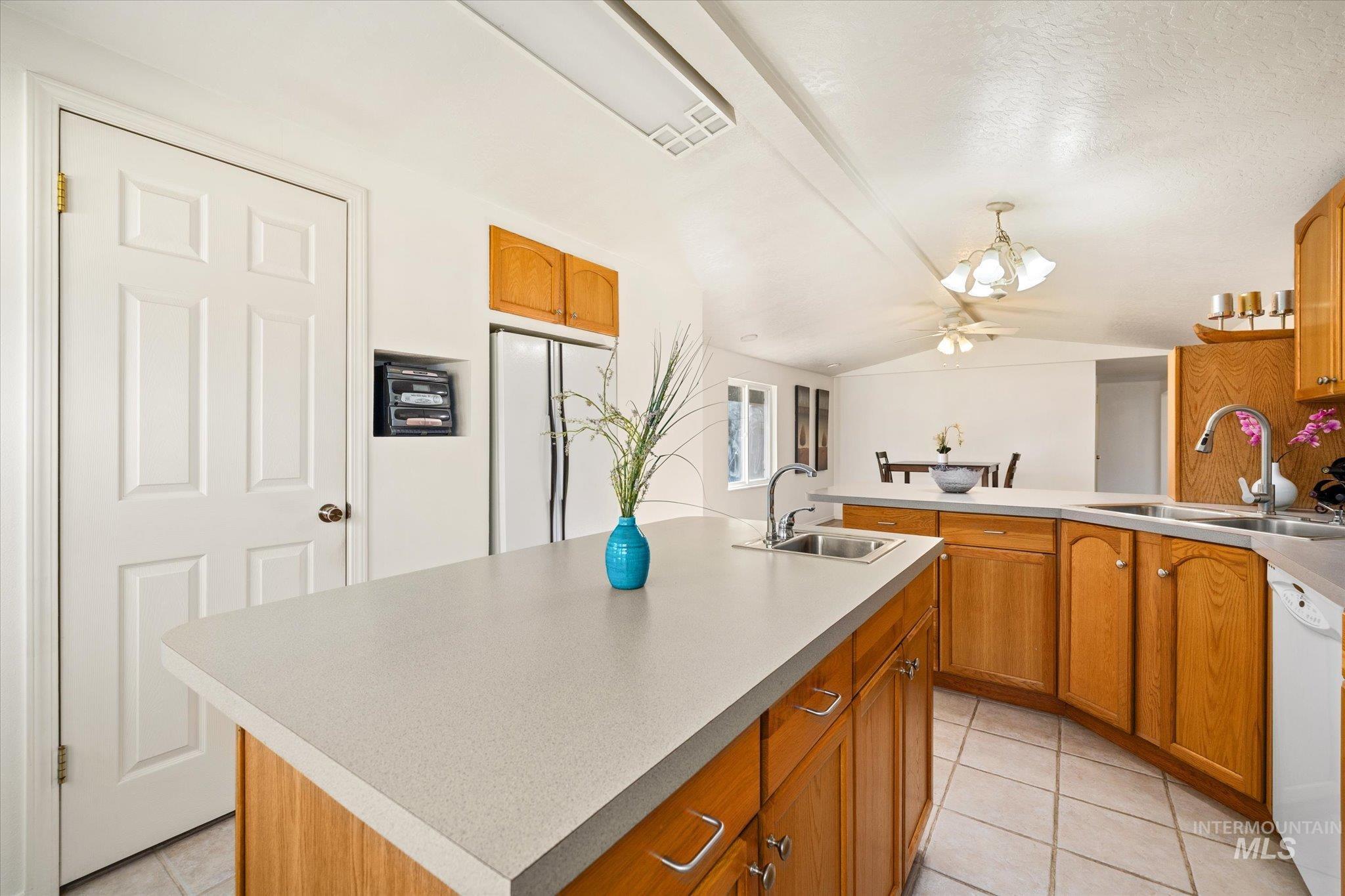 9820 Highway 44 Middleton, ID 83644 - Photo 24 of 50 Kitchen with a peninsula, an island with sink, light countertops, white appliances, and light tile patterned flooring