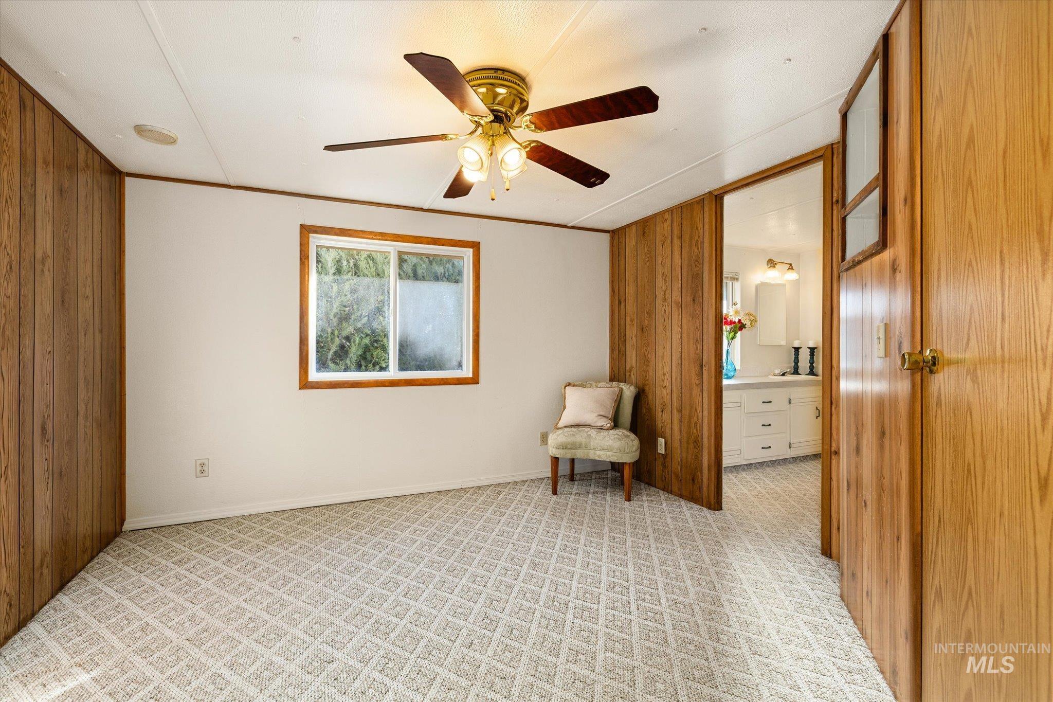 9820 Highway 44 Middleton, ID 83644 - Photo 36 of 50 Unfurnished room featuring wood walls, light carpet, and a ceiling fan