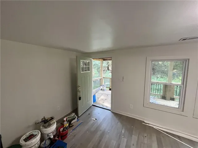 an empty room with wooden floor and windows