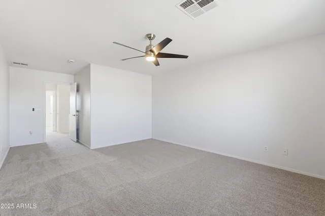 an empty room with a window and a ceiling fan