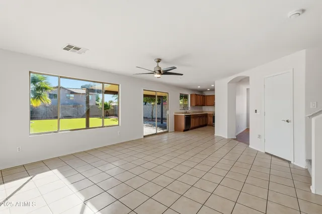 a view of an empty room with a window and a kitchen