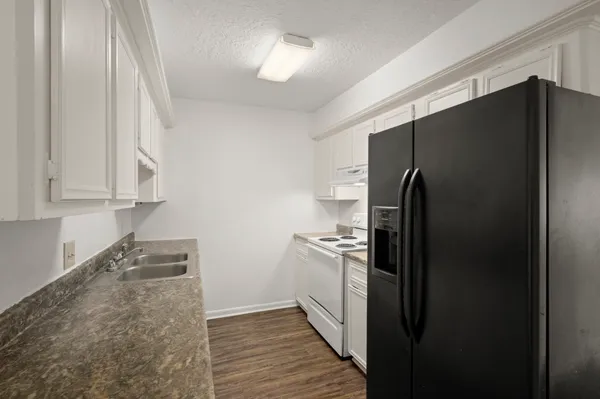 a kitchen with stainless steel appliances granite countertop a refrigerator and a sink