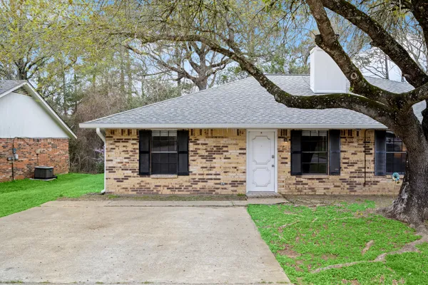 a front view of a house with yard and green space