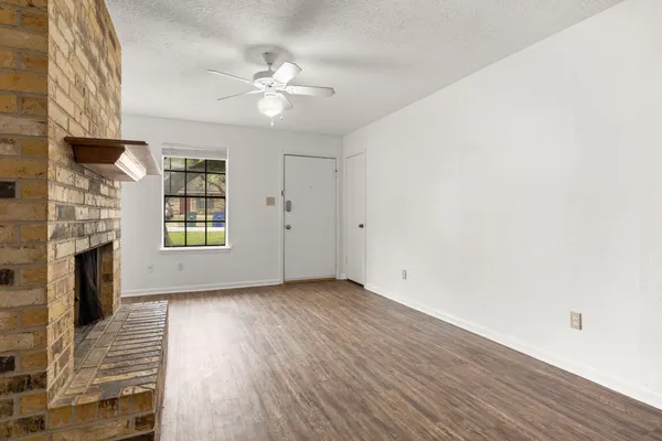 a view of an empty room with a fireplace and a window
