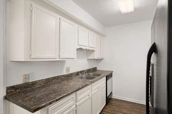 a kitchen with granite countertop a sink stove and cabinets