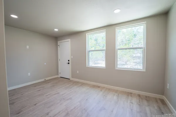 a view of an empty room with wooden floor