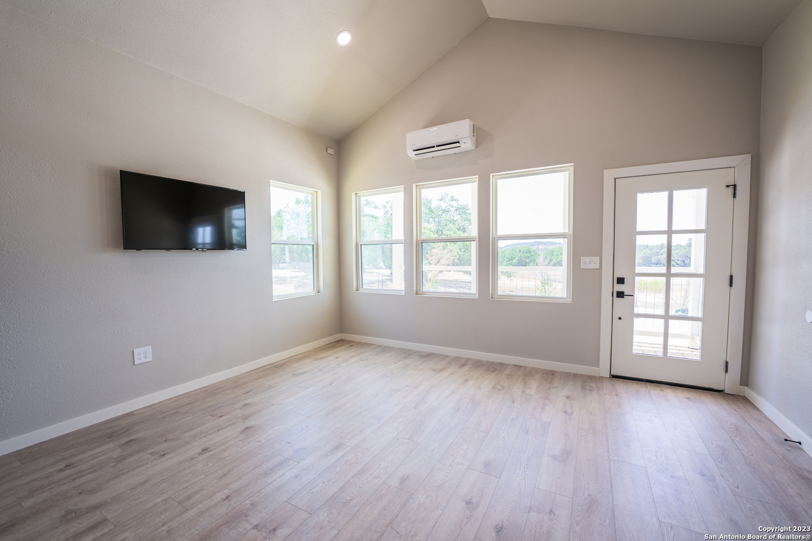1225 Texas Oaks, Unit D Spring Branch, TX 78070 - Photo 5 of 20 an empty room with wooden floor and windows