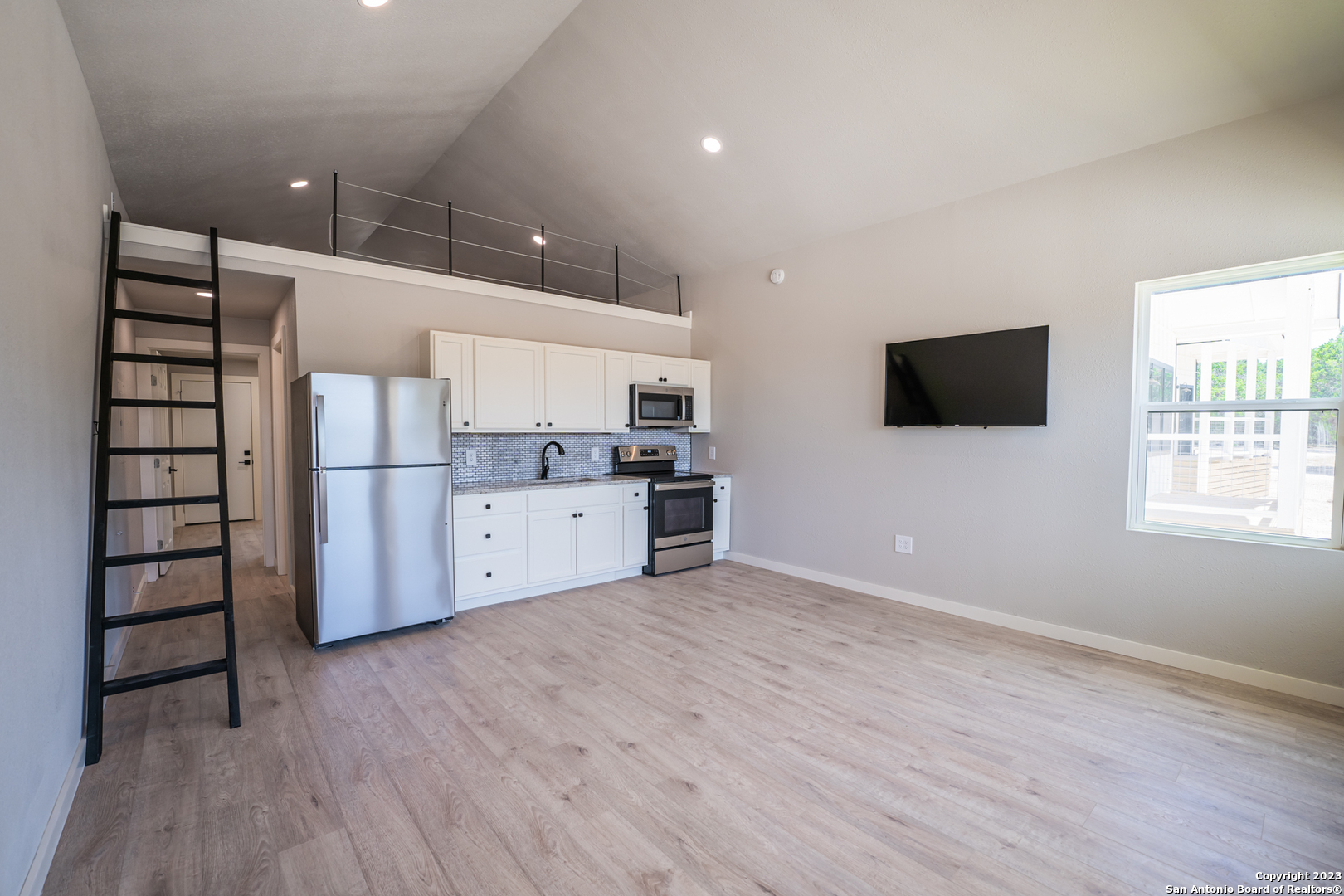 1225 Texas Oaks, Unit D Spring Branch, TX 78070 - Photo 6 of 20 a view of a kitchen with wooden floor and electronic appliances