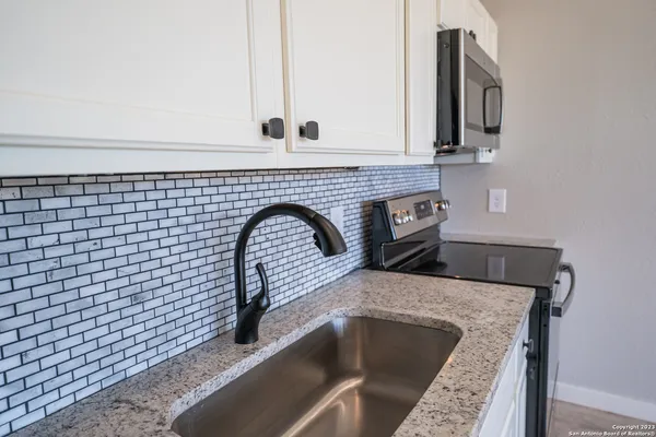 a bathroom with a granite countertop sink a toilet and shower