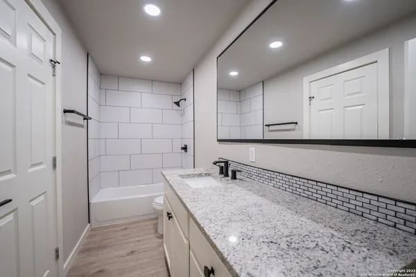 a bathroom with a granite countertop sink and a mirror