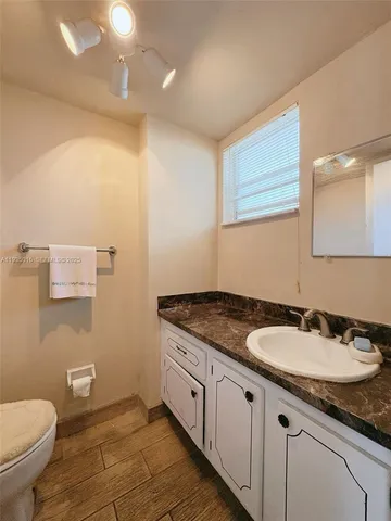 a kitchen with white cabinets and refrigerator