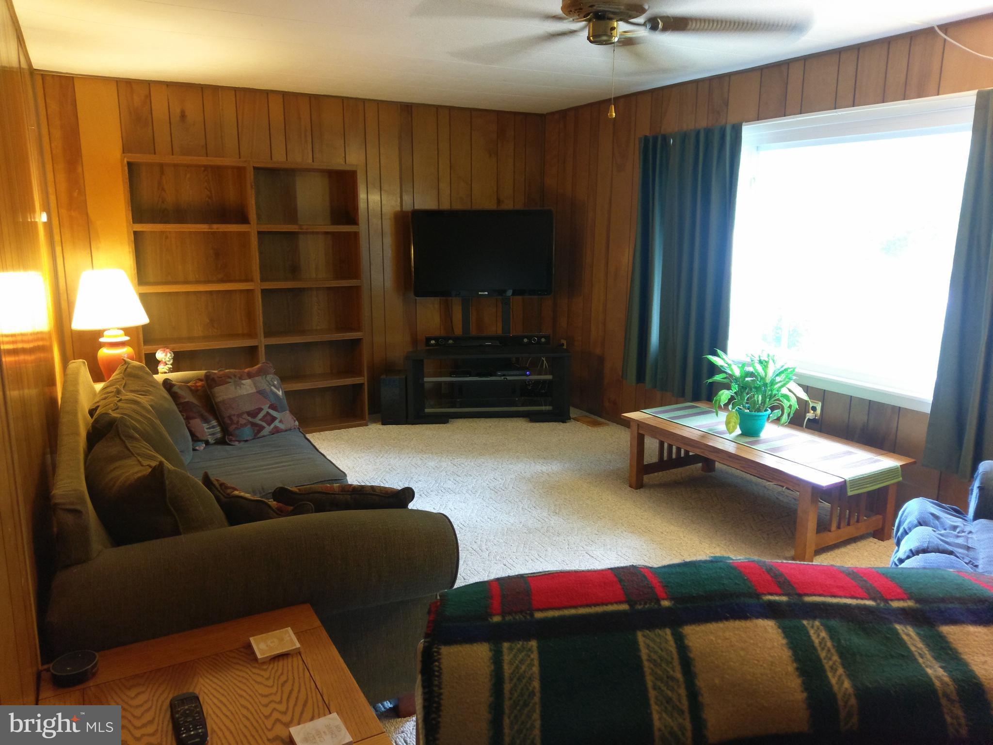 12820 Rousby Hall Road Lusby, MD 20657 - Photo 13 of 39 a living room with furniture and a flat screen tv
