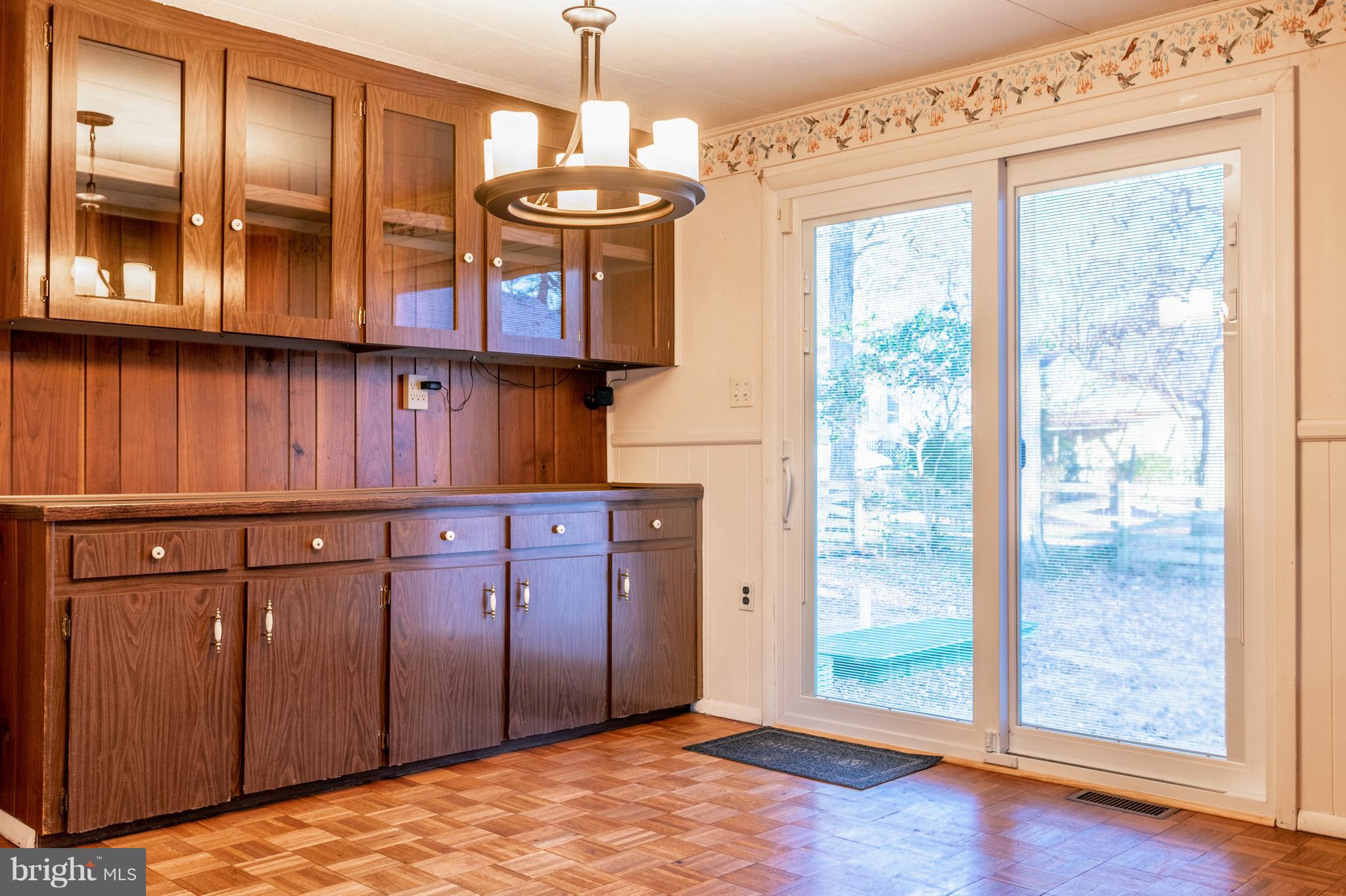 12820 Rousby Hall Road Lusby, MD 20657 - Photo 16 of 39 a view of a kitchen with wooden floor and chandelier