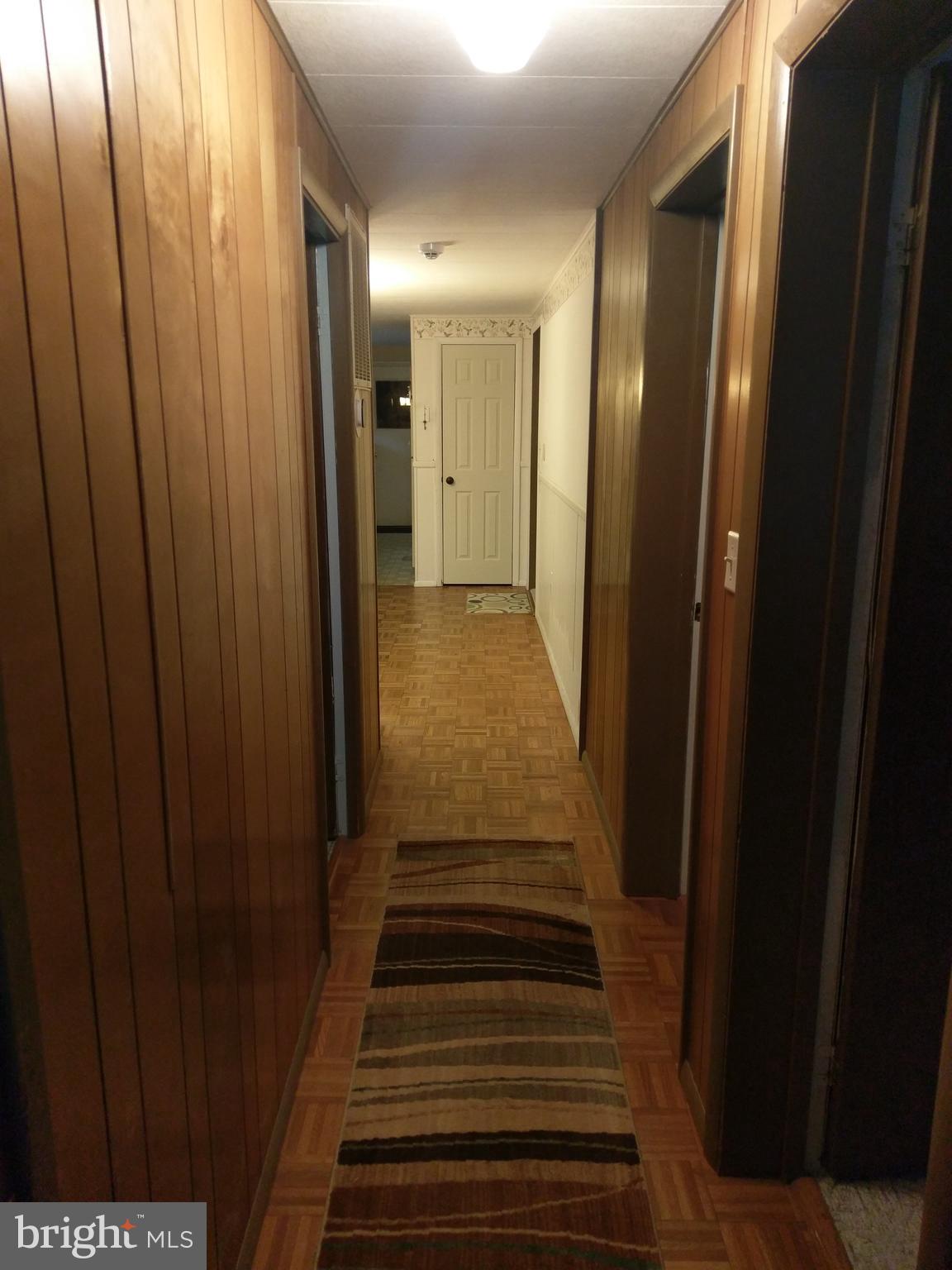 12820 Rousby Hall Road Lusby, MD 20657 - Photo 18 of 39 a view of a hallway with wooden floor and stairs