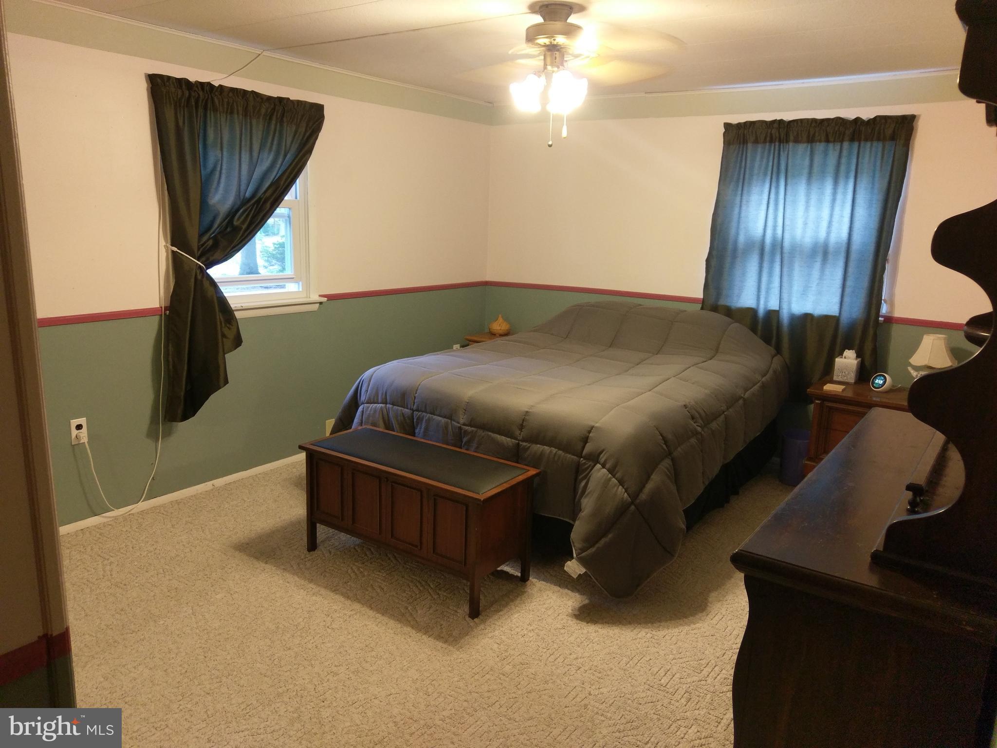 12820 Rousby Hall Road Lusby, MD 20657 - Photo 20 of 39 a bedroom with a bed and a chandelier