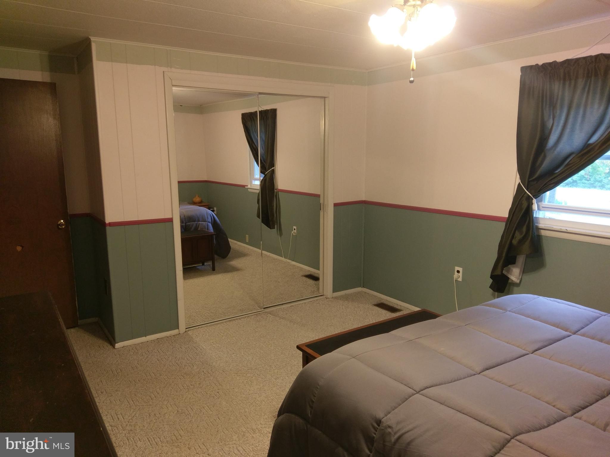 12820 Rousby Hall Road Lusby, MD 20657 - Photo 21 of 39 a bedroom with a bed and a potted plant
