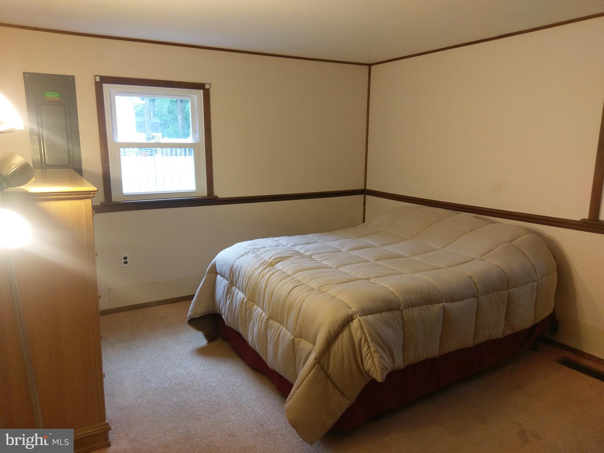 12820 Rousby Hall Road Lusby, MD 20657 - Photo 22 of 39 a bed sitting in a bedroom next to a window